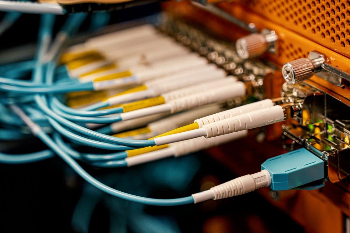 Cable MPO-12 de fibra óptica utilizado con módulos QSFP+ SR4 y PSM4 en instalaciones de datacenter, mostrando el conector de 12 fibras que permite la conexión de los 4 canales de 10G del módulo QSFP+ a través de una única terminación